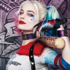 Dziewczyna Jokera, Harley Quinn, z pałką baseballową i charakterystycznym makijażem, pozuje na tle graffiti.