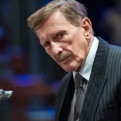 Jan Englert w eleganckim garniturze, z ozdobną laską w kształcie głowy psa. Widać jego charakterystyczny wąs.