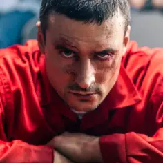 Mateusz Damięcki w czerwonym stroju, z widocznymi ranami na twarzy, w kadrze z filmów.