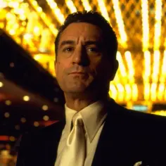 Robert De Niro w eleganckim garniturze, w blasku neonów, jak w swoich najlepszych filmach.