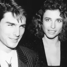 Młody Tom Cruise z żoną Mimi Rogers, uśmiechnięci i patrzący w obiektyw.