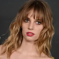 Maya Hawke, znana z filmów, seriali i programów, z burzą blond włosów i wyrazistymi ustami.