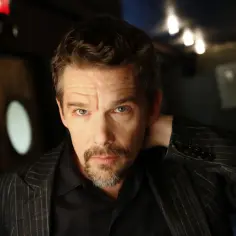 Ethan Hawke, znany z wielu świetnych ethan hawke filmów, w zbliżeniu. Ma na sobie elegancki, pasiasty garnitur.