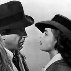 Ikoniczna scena z filmu Casablanca. Bogart i Bergman, gwiazdy casablanca obsada, patrzą na siebie z napięciem.
