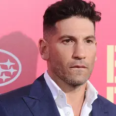 Jon Bernthal, znany z filmów, seriali i programów, na tle różowego banera z logo Subaru i napisem "BABY DRIVER".