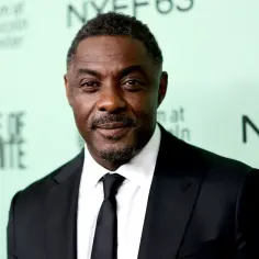 Idris Elba, gwiazda filmów, seriali i programów, w eleganckim czarnym garniturze.