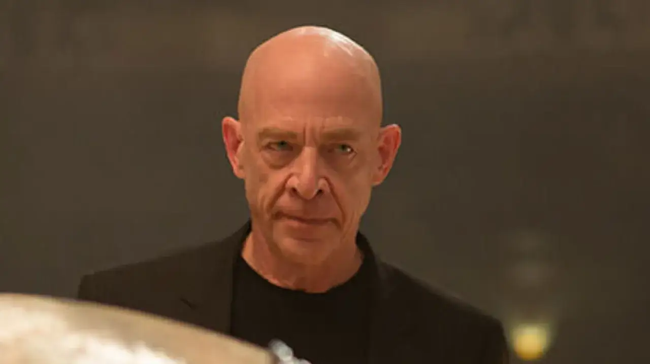 J.K. Simmons jako Terence Fletcher w filmie Whiplash. Jego surowe spojrzenie sugeruje, że nie toleruje błędów.