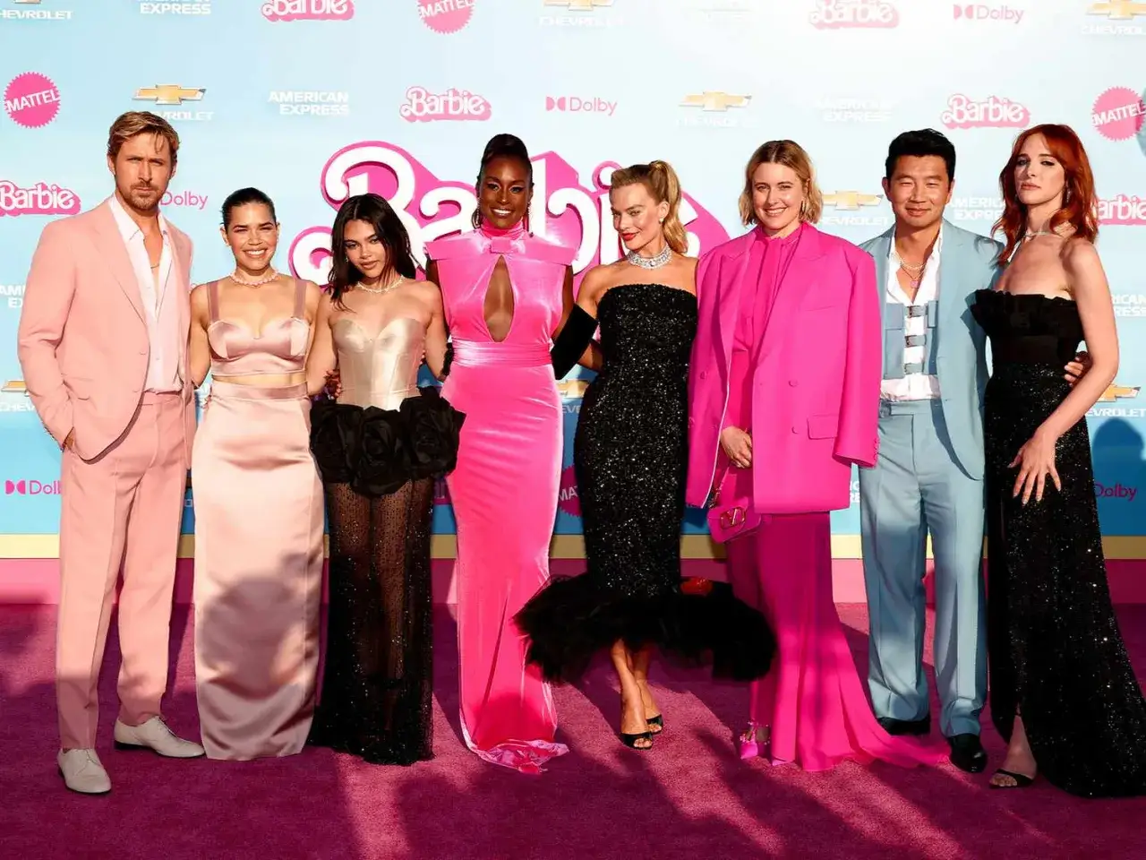 Obsada filmów Barbie na różowym dywanie. Ryan Gosling, America Ferrera, Issa Rae, Kate McKinnon, Margot Robbie, Greta Gerwig, Simu Liu i Alexandra Shipp pozują do zdjęć.