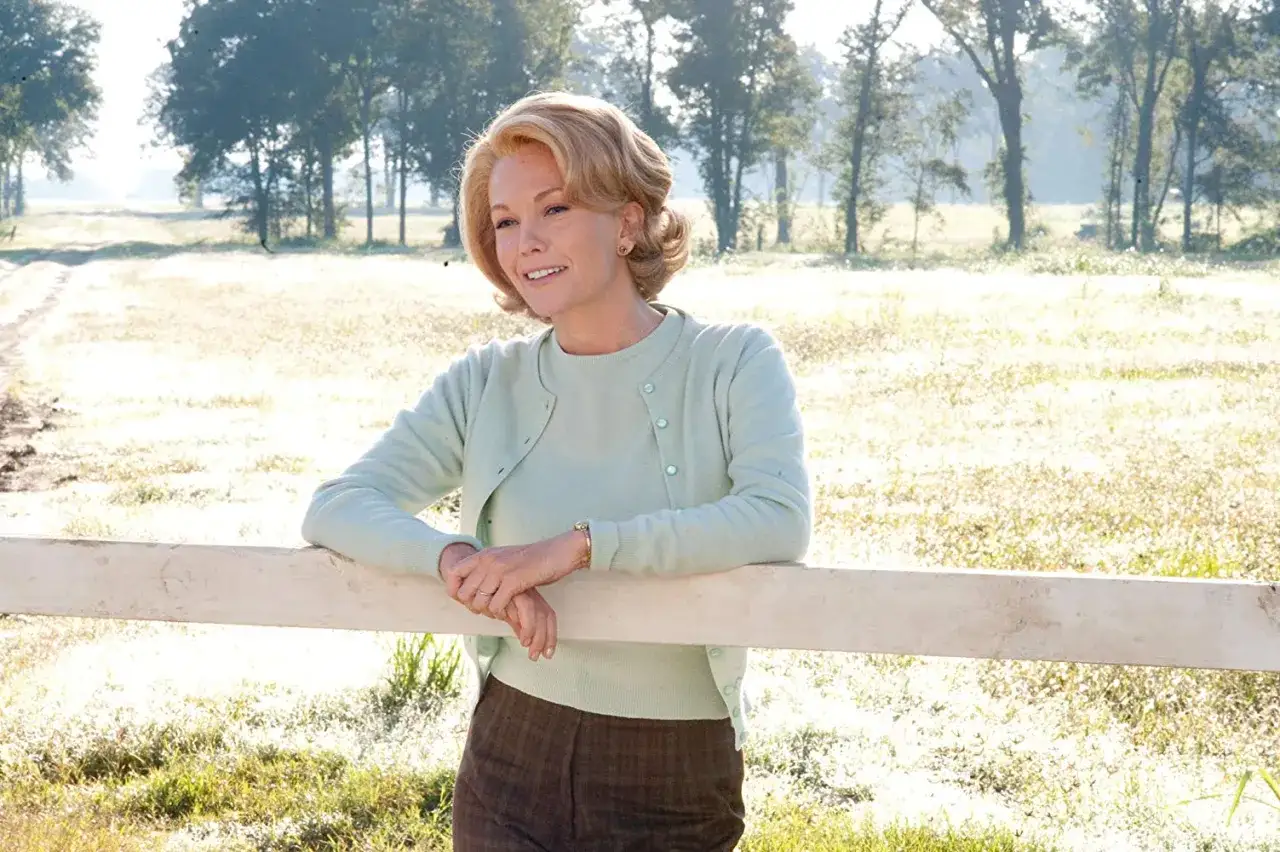 Diane Lane w roli matki, oparta o płot na tle wiejskiego krajobrazu. Scena z jednego z jej filmów.