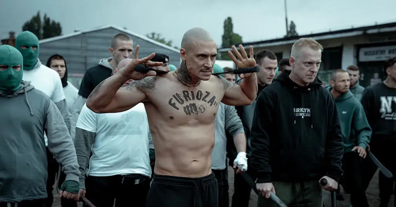 Mateusz Damięcki w filmach często wciela się w role twardzieli. Tutaj w scenie z nożem, otoczony przez grupę mężczyzn.