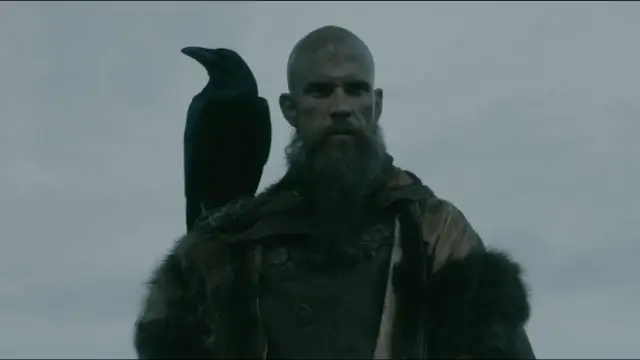 Floki, wiking z krukiem na ramieniu, patrzy wprost przed siebie.